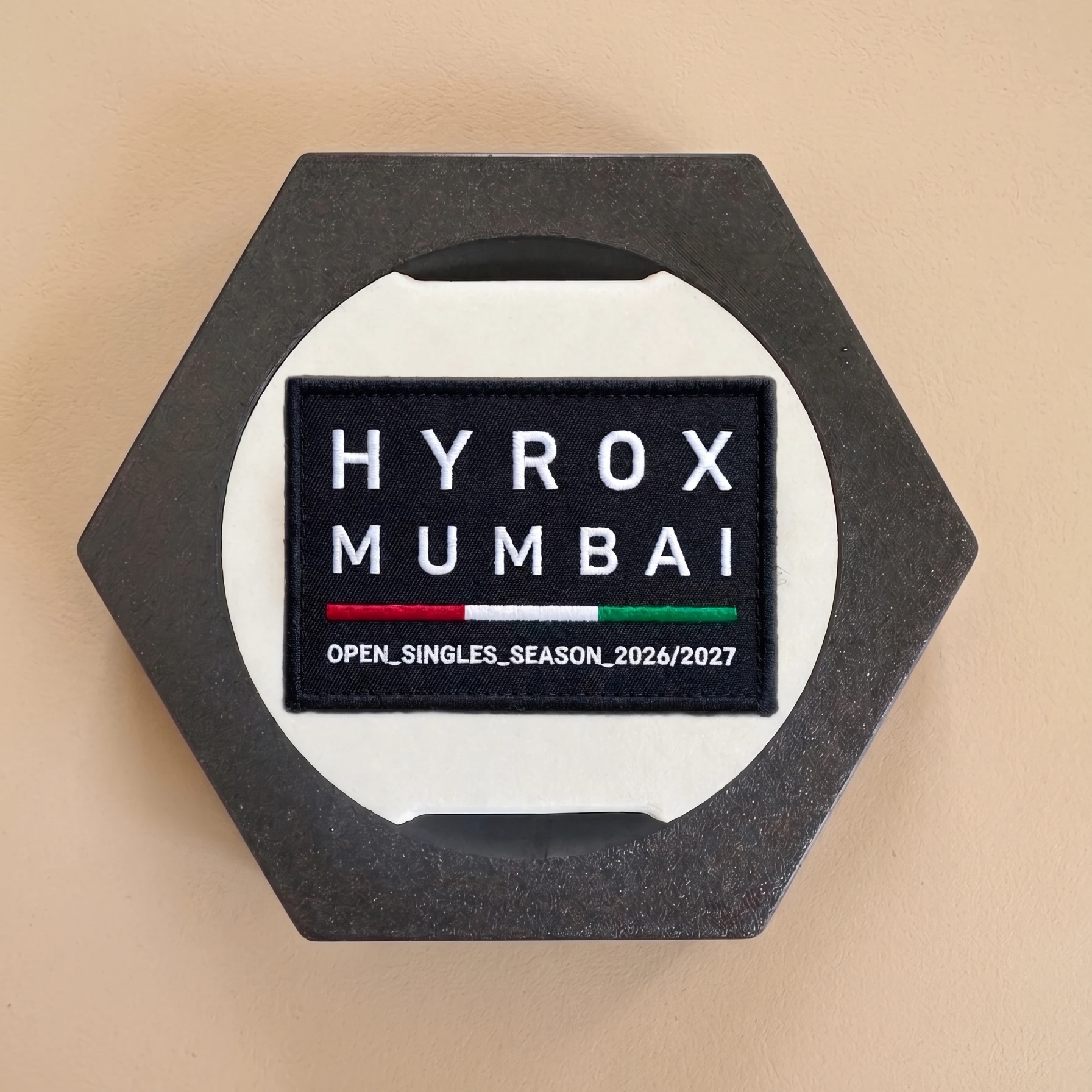Charcoal hexagonal Patch Frame showing a HYROX Mumbai race patch.
